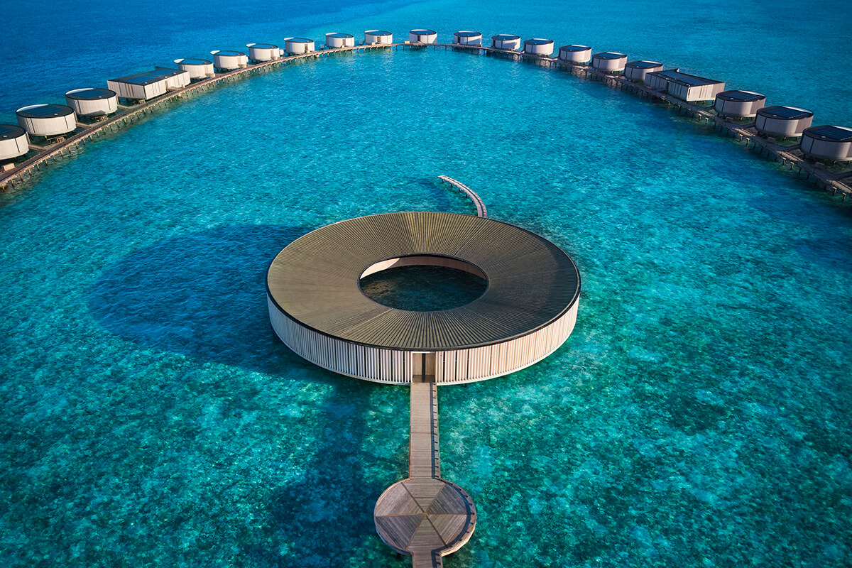 The Ritz Carlton Spa in the Maldives. A circular structure in the ocean surrounded by other indivudal structures floating over water.